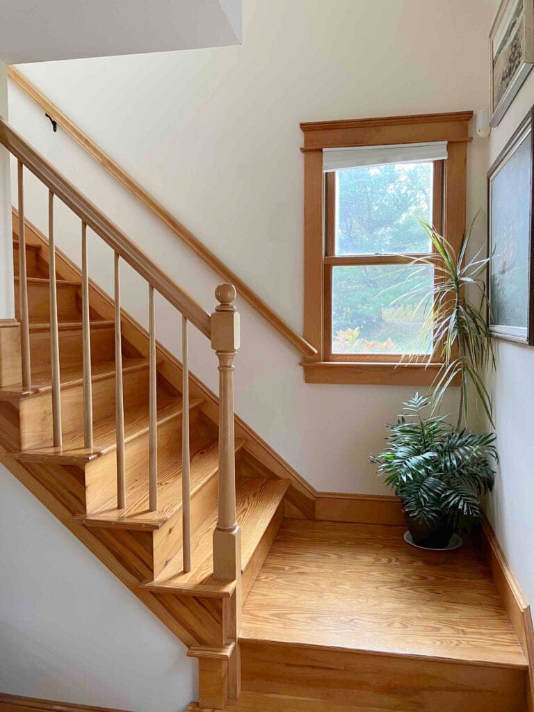 Benjamin Moore Navajo White staircase with pine floors, trims, railings, treads, cream paint color on walls