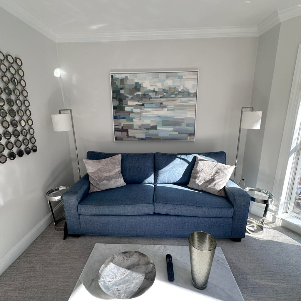 Benjamin Moore Paper White with White OC 151 trim and ceiling, navy blue sofa, gray carpet and accents