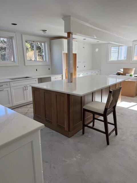 Kraftmaid Frost (white) kitchen cabinest with medium to dark stained wood island and Silestone Et Calacatta Gold white quartz countertop