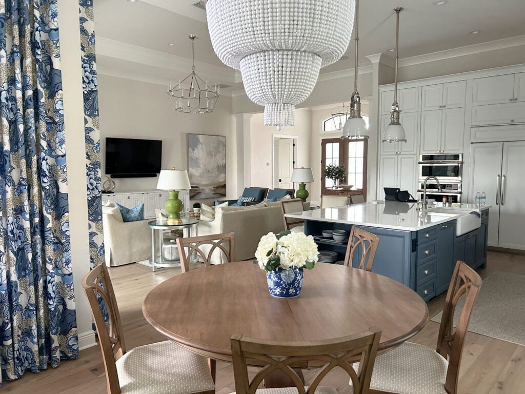 Open concept living room, dining room kitchen, traditional transitional style, wood floor, PPG Paraffin neutral walls, white cabinets, blue island