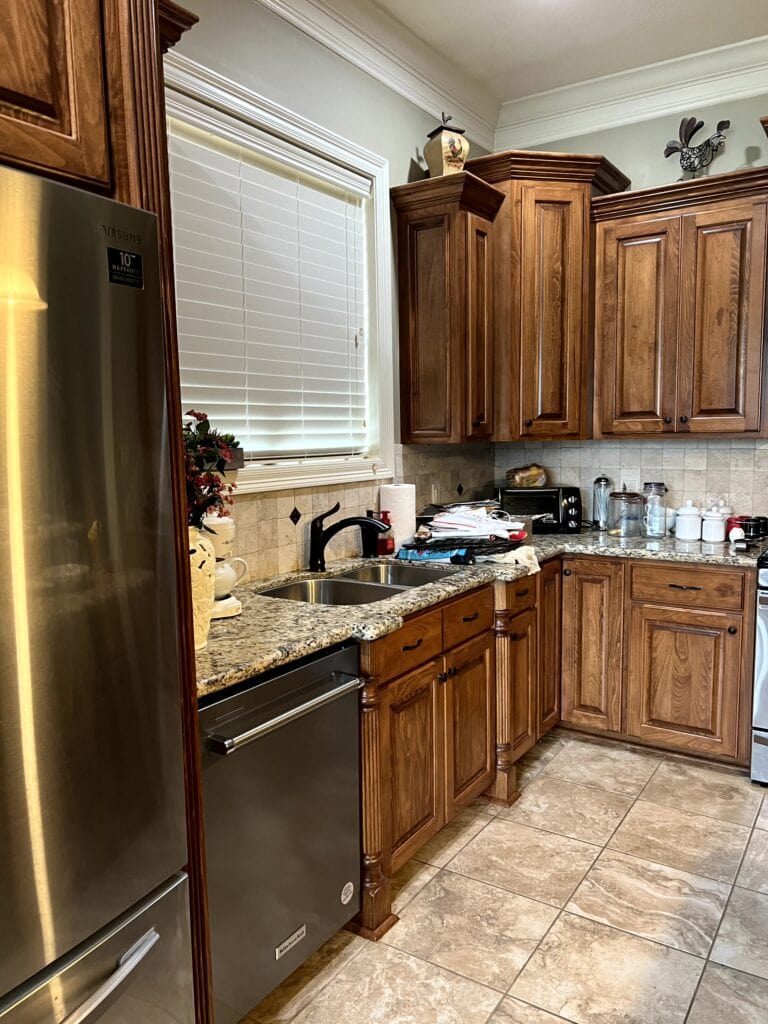 Pine, dark wood kitchen stained cabinets, travertine tile backsplash, santa cecilia granite countertop, 2000s home tuscan or mediterranean style update