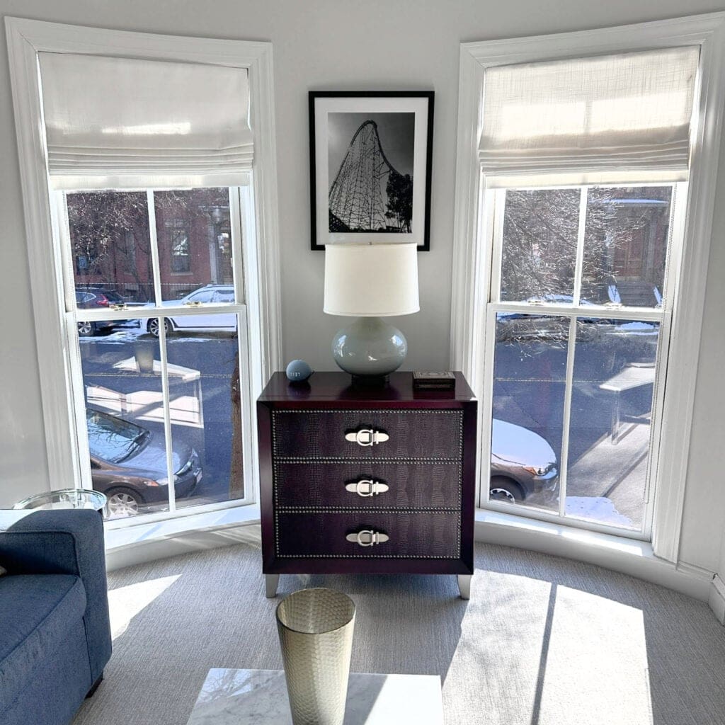 home decor in den with south facing light, gray carpet, blue sofa, Benjamin Moore Paper White, off-white gray on walls, White OC 151 trim