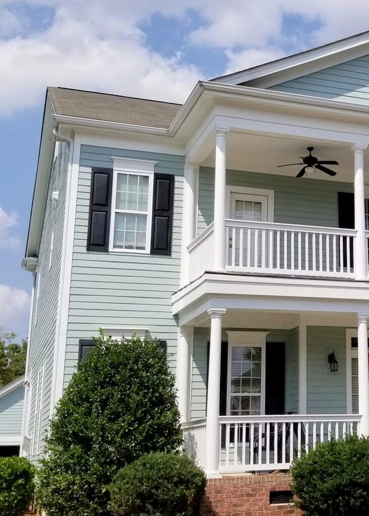 Blue-green exterior paint color, sherwin Williams Quietude, white trim, black shutters, railings