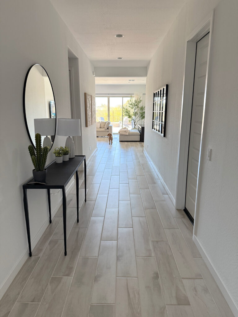 Long hallway, entryway with Sherwin Williams Extra White walls, trims, ceiling, tile wood look floor with taupe white wash, pink tones, home decor. Looking south facing, entryway