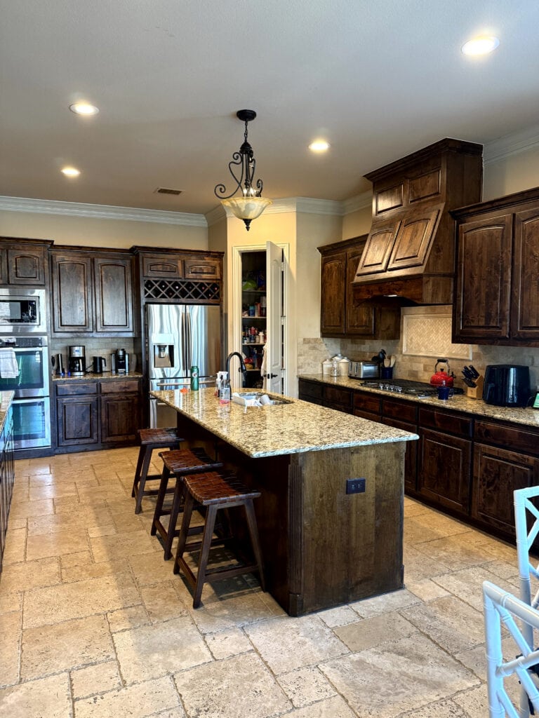 dark wood kitchen cabinets, granite countertop, santa cecilia, travertine tile flooring