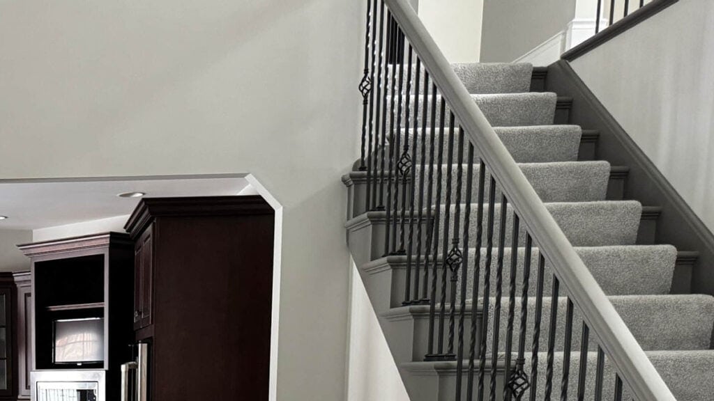 Benjamin Moore London Fog on walls with painted risers and railing of staircase in Sherwin Williasm Urbane Bronze, black spindles