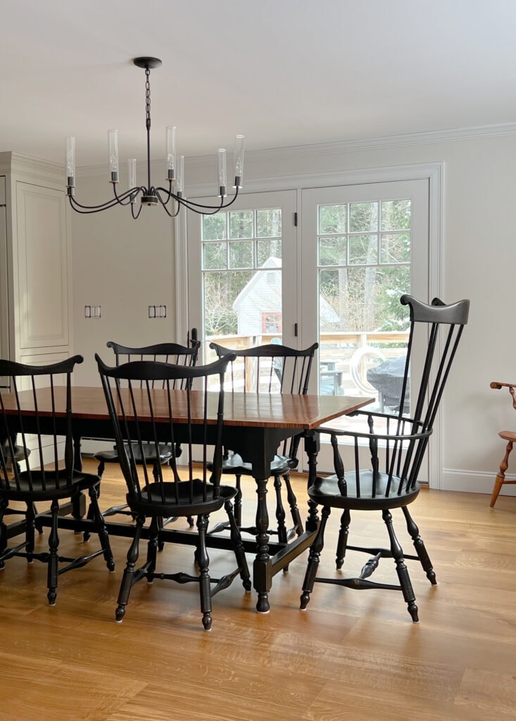 Sherwin Williams Accessible Beige painted kitchen cabinets, Pure White trim, Aesthetic White walls, french doors, modern farmhouse dining table, black chairs, wood floor