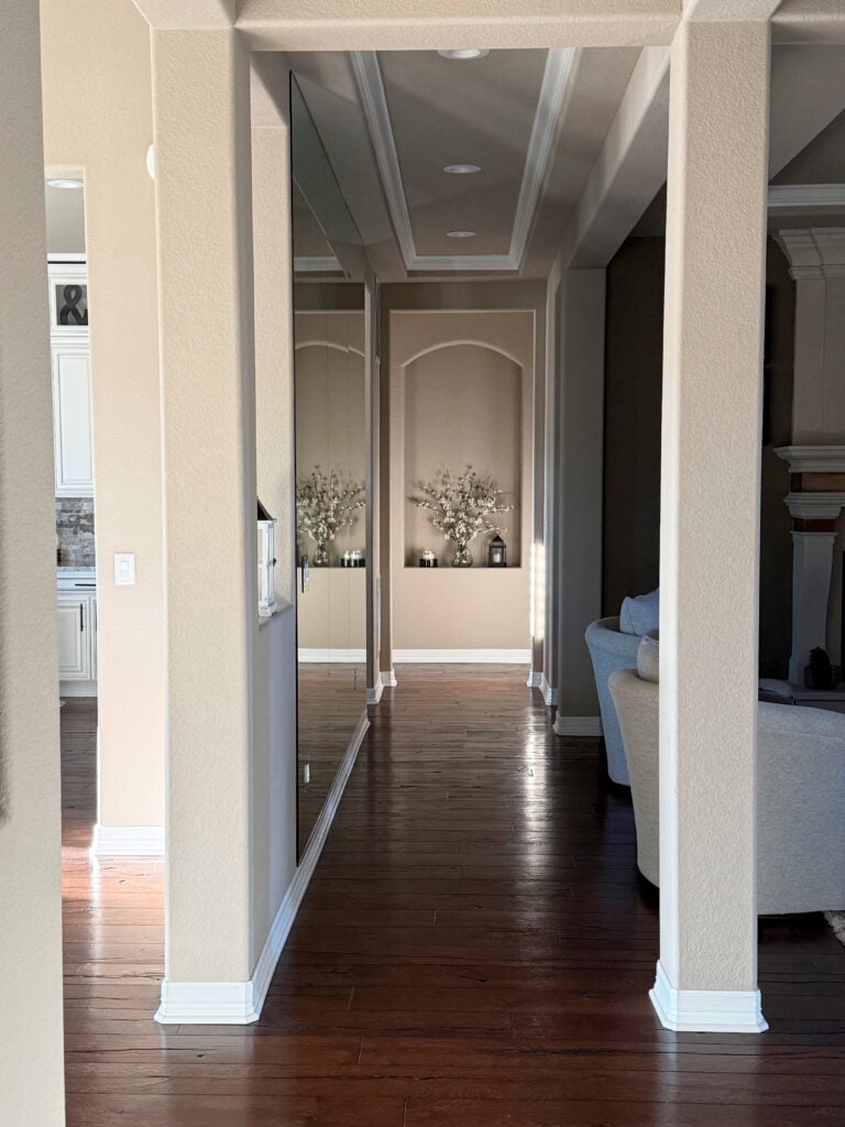 Sherwin Williams Balanced Beige in a dark hallway, dark wood floor, white trim, niche or alcove at end