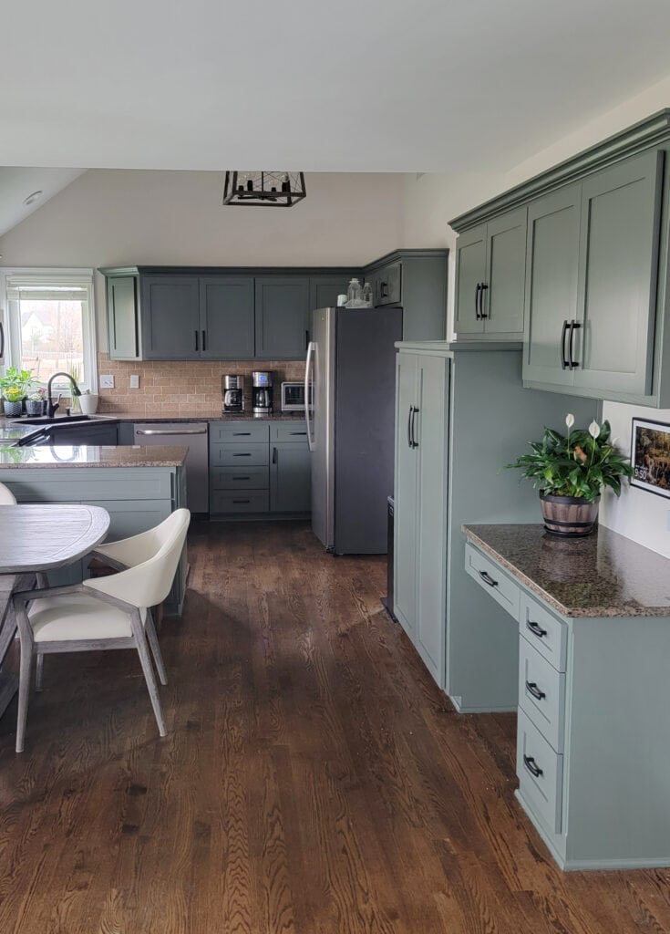 1990s kitchen update ideas, granite countertop, travertine tile backsplash, Egret White walls, Sherwin Williams Pewter Green painted wood cabinets