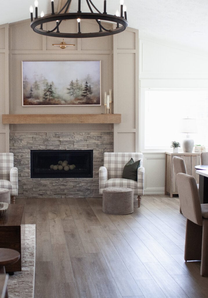 2000s home update ideas, fireplace with gray beige stacked stone, wood mantel, moldings, trims painted Sherwin Williams Balanced Beige, walls Cold Foam, graywash LVP wood look flooring,