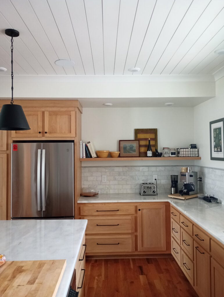 Cherry, maple wood kitchen cabinets, marble countertop and subway tile backsplash, island, red-orange stain wood floor, floating shelf, Alabaster and Pure White, painted wood tongue groove ceiling