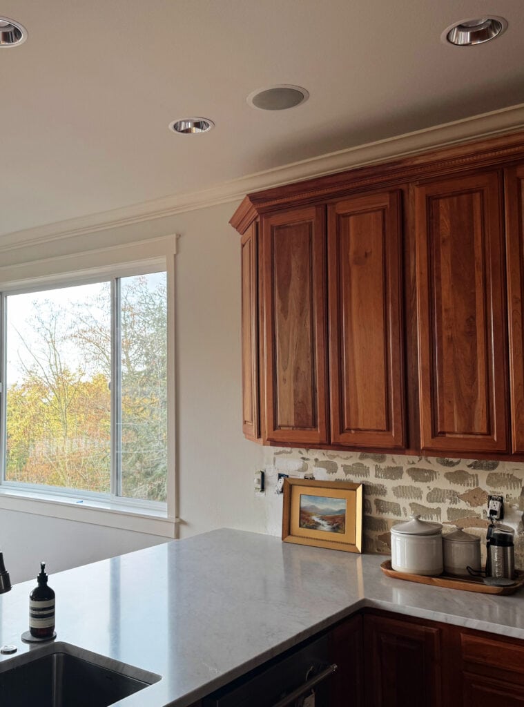 Cream trim with the best light neutral paint color, Ballet White. Dark cherry wood cabinets, marble countertops