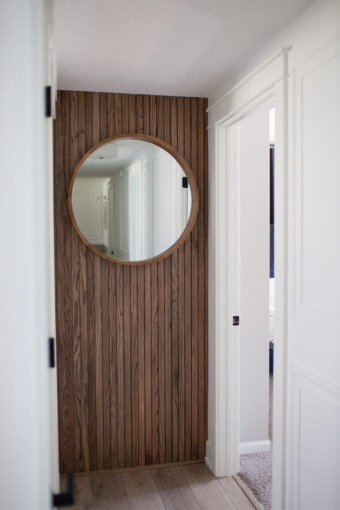 Ideas to add interest to a long or dark hallway, vertical wood slate wall, round mirror, Sherwin Williams Cold Foam warm white