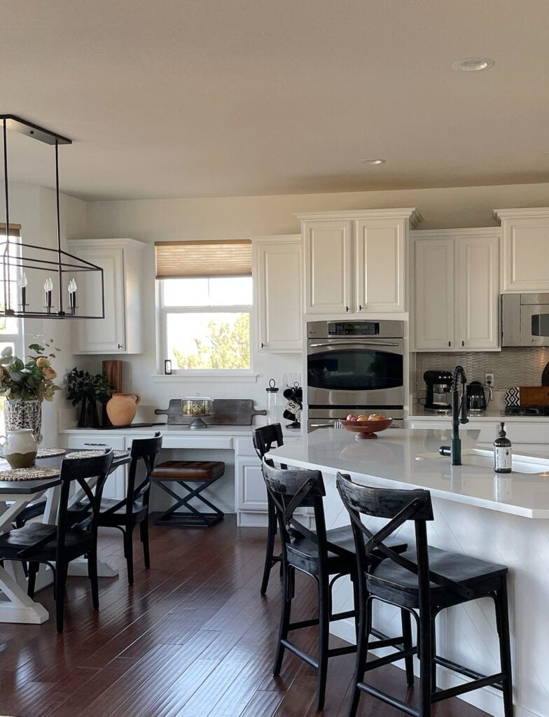 Kitchen cabinets painted Sherwin Williams Pure White and walls, dark wood floor, black modern farmhouse chairs, home decor, quartz countertop,