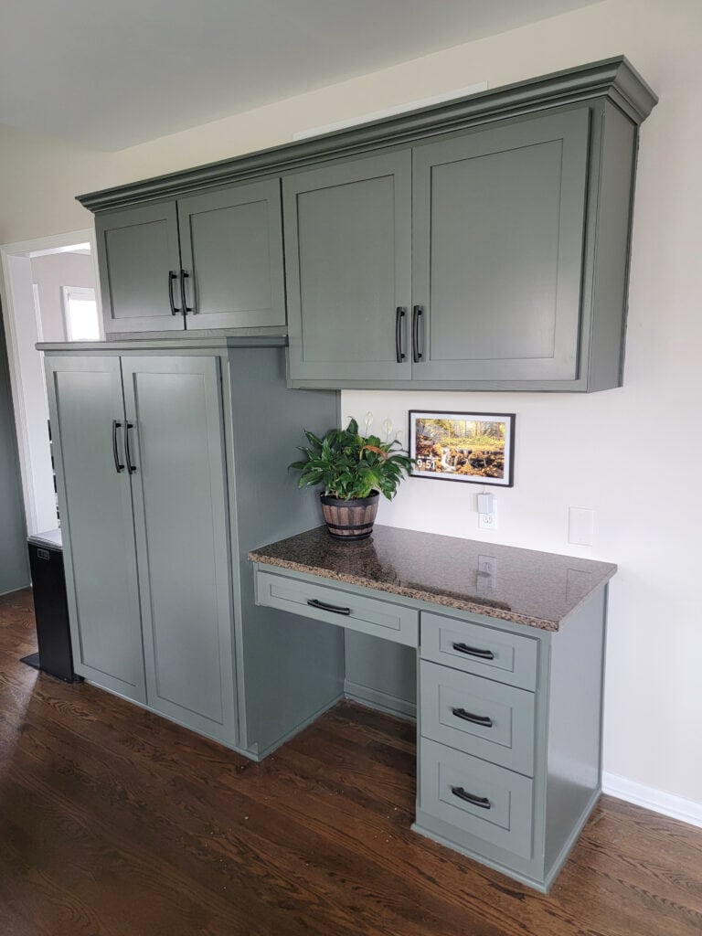 Kitchen cabinets painted best green paint color, Sherwin Williams Pewter Green, granite countertop, dark wood floor, black hardware, Egret White walls