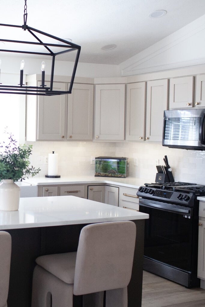 Kitchen painted wood cabinet update, black appliances, white quartz, Sherwin Williams Balanced Beige cabinet, Zellige tile backsplash, gold hardware