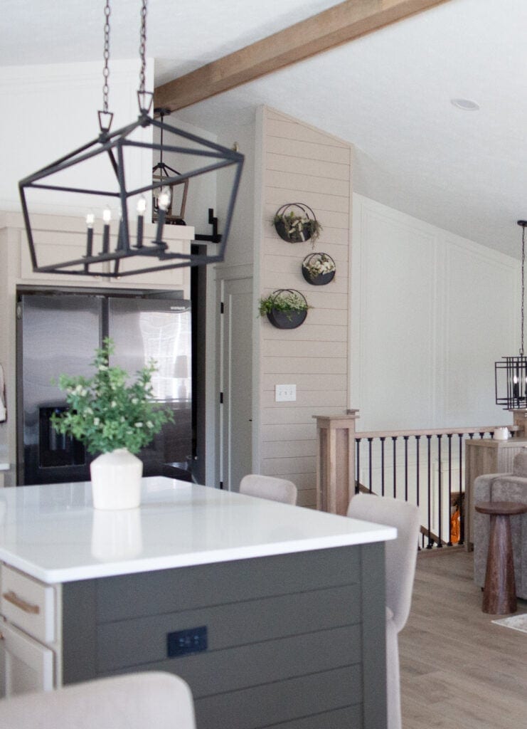 Kitchen with Sherwin Williams Thunder Gray painted island with shiplap feature, Balanced Beige, Cold Foam, wood beam in vault, black fridge