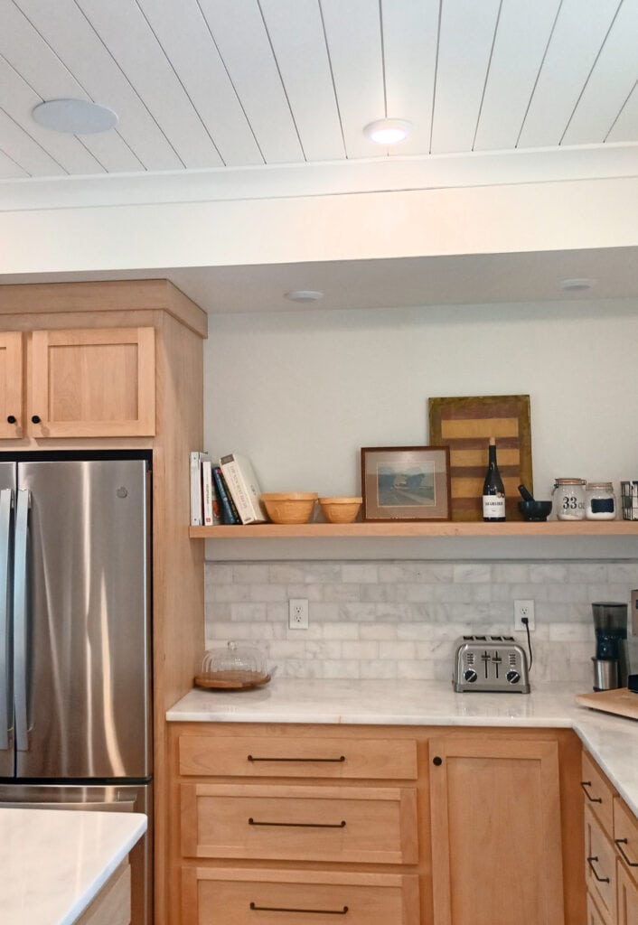 Kitchen with maple or cherry wood cabinets, marble countertop, subway tile marble backsplash, floating wood shelf, home decor, tongue and groove painted white ceiling, Pure White and Alabaster