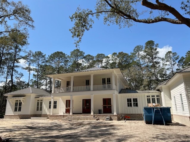 Medium bronze metal roof, Benjamin Moore Swiss Coffee board and batten and horizontal siding, mahogany front doors, Savannah Gray and Georgetown brick on foundation and steps