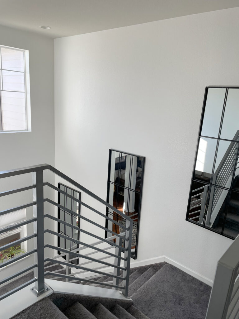 Modern staircase, gray horizontal metal railings, dark gray carpet, Sherwin Williams Pure White walls