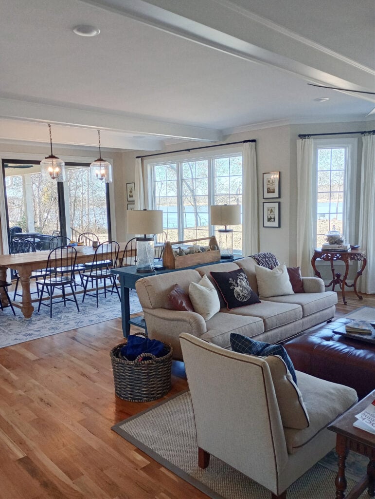 Open concept livingroom and dining room, Pure White ceiling and painted wood beams, wood floor, beige furniture, Winds Breath walls