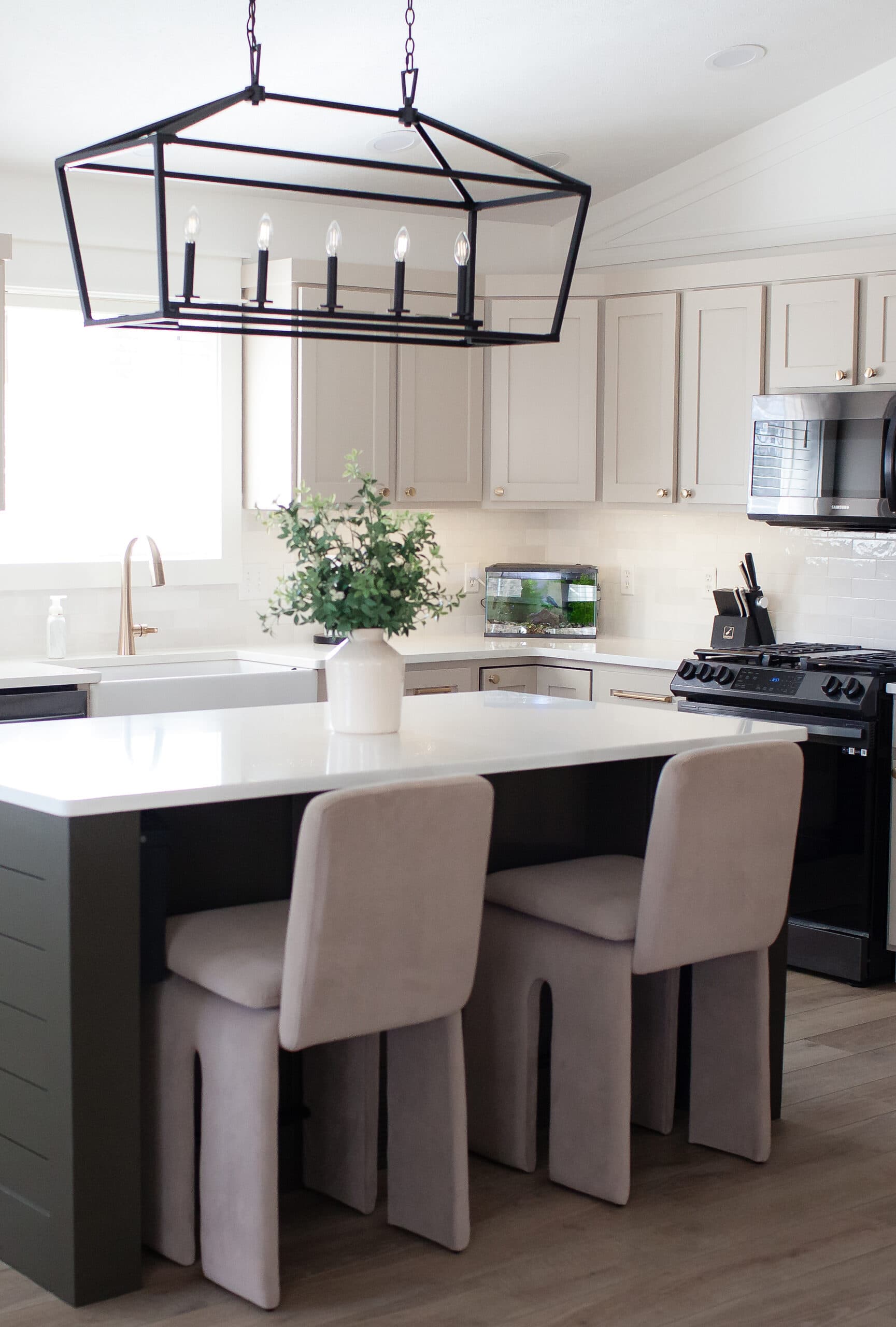 Sherwin Williams Balanced Beige painted wood kitchen cabinets, white quartz, zellige tile backsplash, black appliances, Thunder Gray island