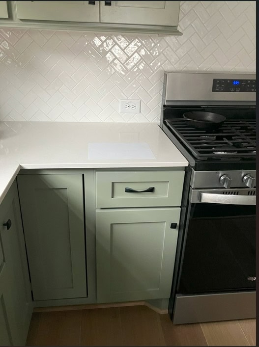 Sherwin Williams Evergreen Fog, sage green painted kitchen cabinets, white herringbone subway tile backsplash, white quartz countertop, black hardware