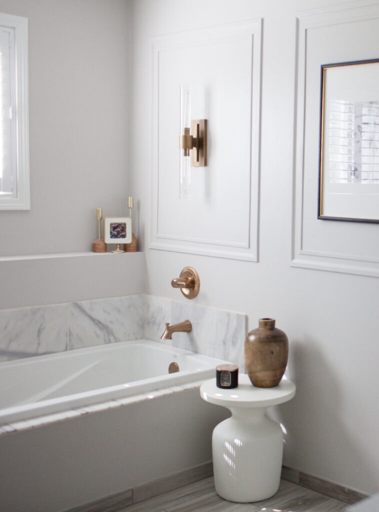 Soaker bathtub, marble tile surround, copper finish on faucet and light fixture, Sherwin Williams On the Rocks gray walls