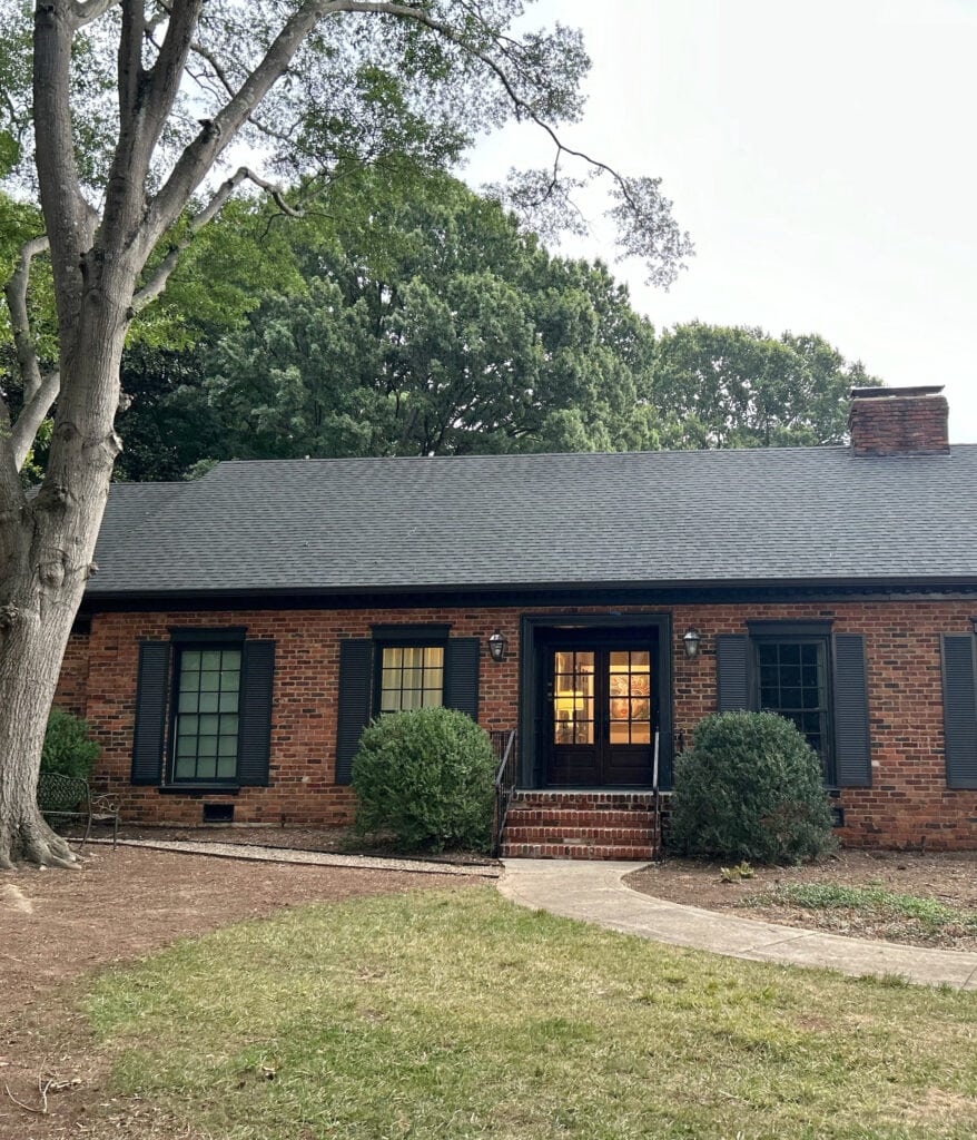 exterior with red orange brick, dark soft black shutters, painted windows, trims, double front door (2)