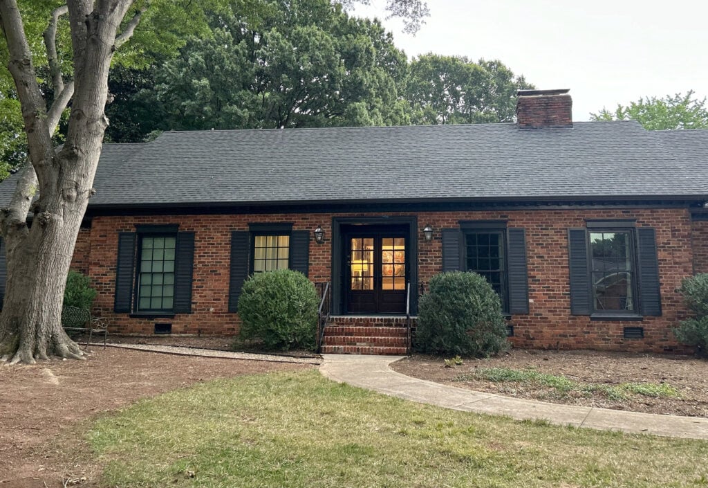exterior with red orange brick, dark soft black shutters, painted windows, trims, double front door (3)