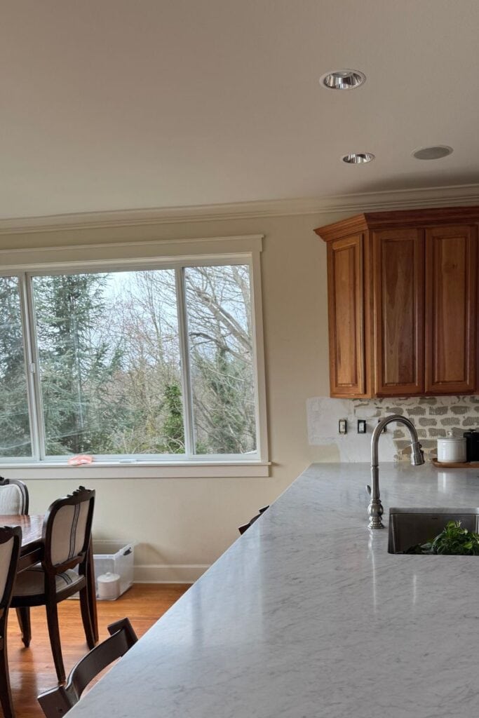 BEFORE kitchen with marble countertop, cherry wood red stained cabinets, cream walls, cream trim around windows
