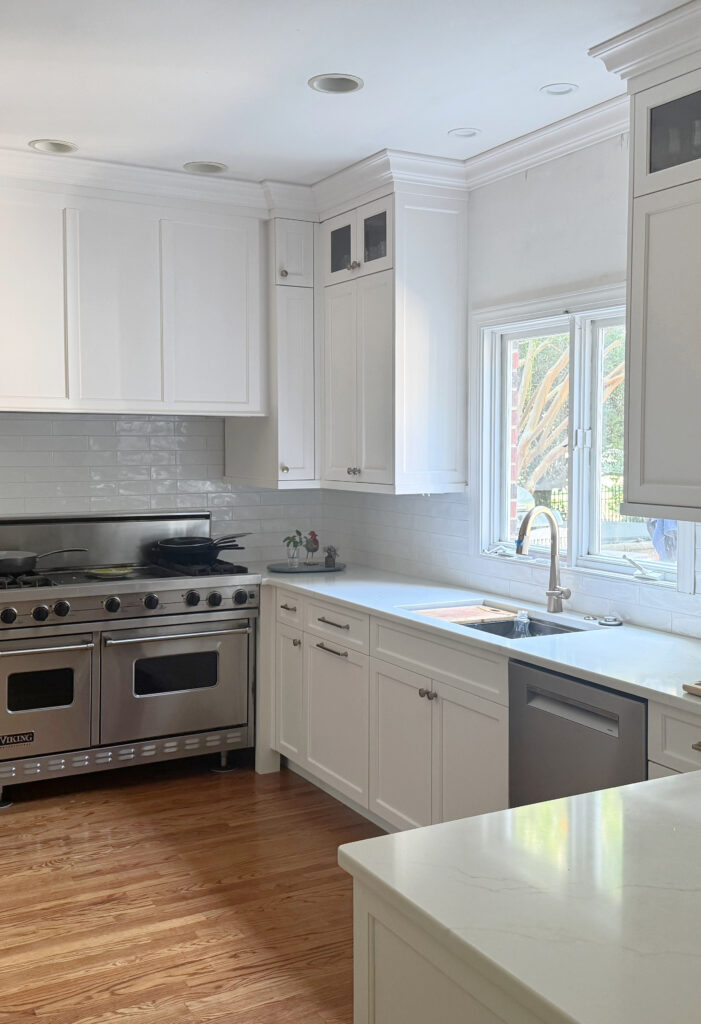 Benjamin Moore White Dove painted cabinets, Miraggio white quartz countertop, subway tile backsplash oak tile floor in kitchen, stainless apliances, brass hardware (1)