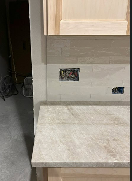 Quartzite Perla Bianca looks like Taj Mahal kitchen countertop with subway tile backsplash and wood cabinets