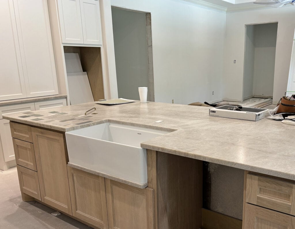 Quartzite kitchen countertop, Perla Bianca, similar to Taj Mahal, white oak stained island with sink. Weathered oak blend