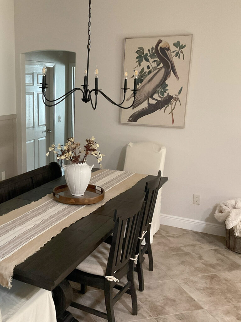 Beige and taupe tile floor, Sherwin Williams Aesthetic White, off-white paint color on walls, dark wood stained black dining room furniture