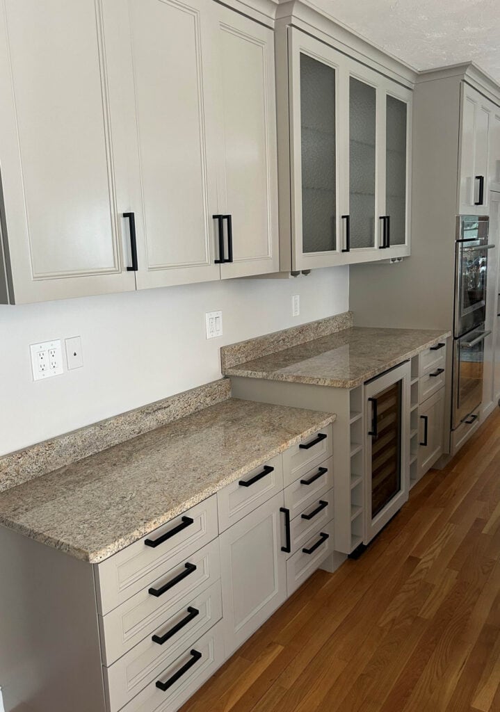 Benjamin Moore Plymouth Rock, Valley Forge Tan, painted maple wood cabinets, black hardware, granite countertop, Sherwin Williams Windfresh White paint on walls