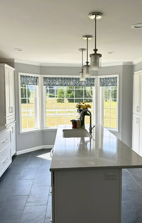 Dark slate gray tile floor, light gray quartz countertop, Benjamin Moore Silver Chain paint oclor, blue accent valance over bay window, white trim