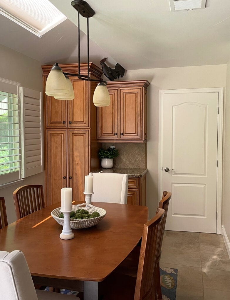 Orange stained wood kitchen (maybe maple) cabinets, Sherwin Williams Natural Linen beige paint color on walls, Moderate White lightened on doors and trims