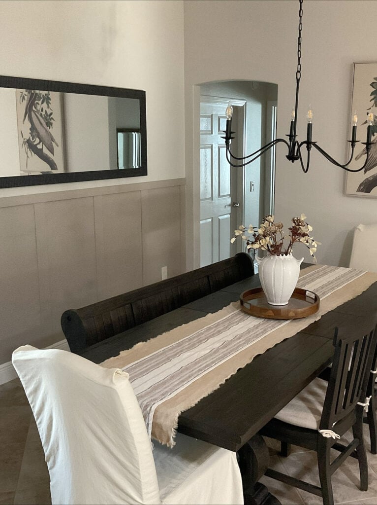 dining room with board and batten accent or feature wall painted Sherwin Williams Balanced Beige, main walls off-white Aesthetic White, dark wood stained black furniture, home decor, mirror