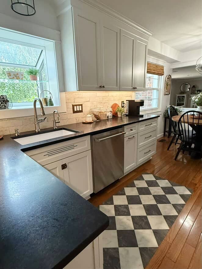 Honed black granite countertops, oak flooring, 1990s kitchen with painted wood cabinets in Sherwin Williams Pure White