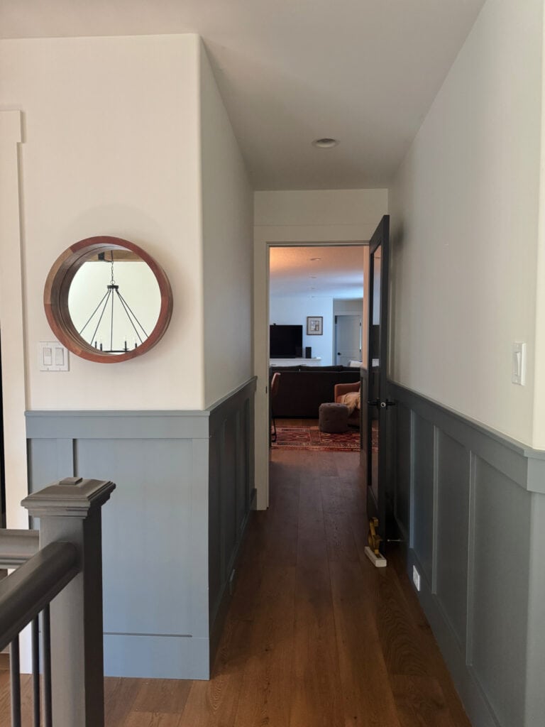 Sherwin Williams Foggy Day, blue-gray paint color on board and batten in dark hallway, Benjamin Moore White Dove upper walls and ceiling, trims, oak flooring