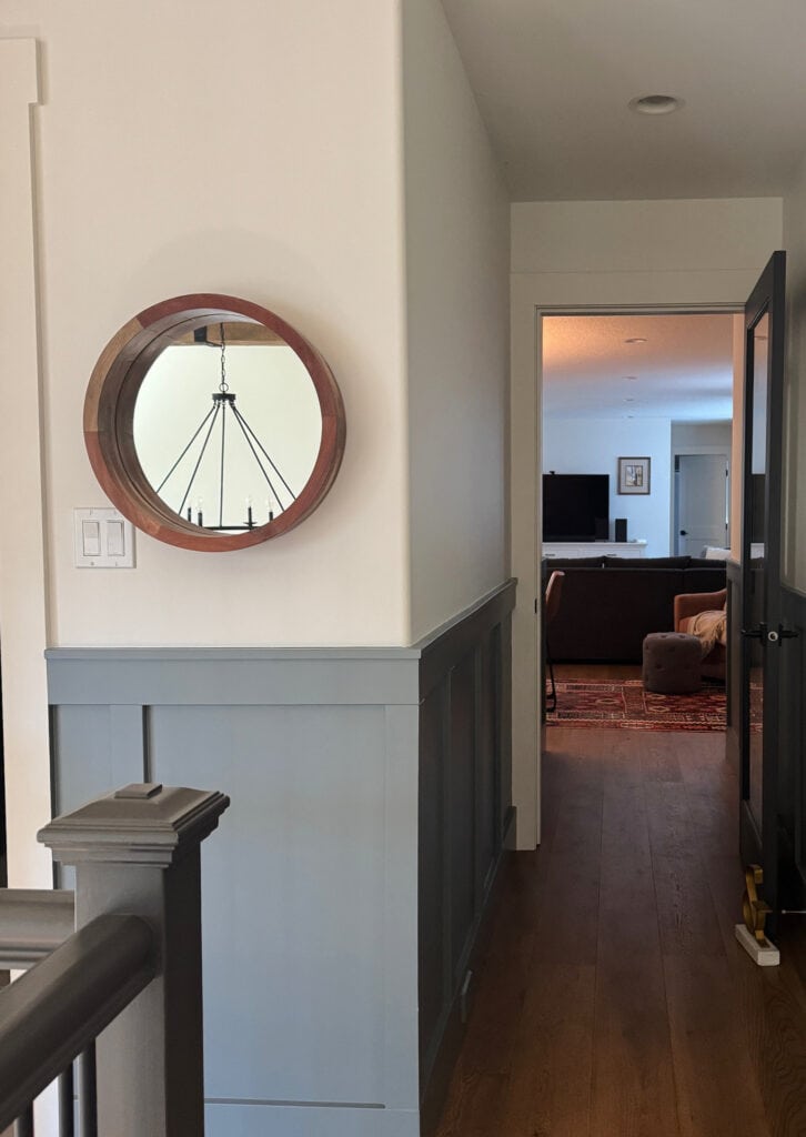 Sherwin Williams Foggy Day painted board and batten in dark hallway, White Dove uppoer walls, Urbane Bronze painted stair railing