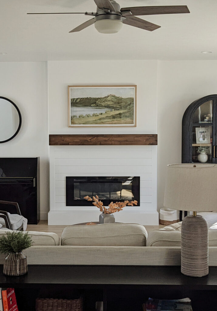 Sherwin Williams Pure White in transitional living room, shiplap on fireplace and wood mantel, black piano, home decor, sofa, arched cabinet