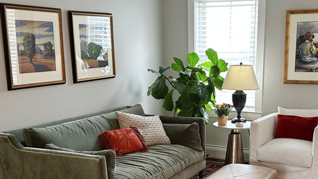 Sherwin Williams Repose Gray in den with green velvet sofa, wood flooring, natural lighting (1)