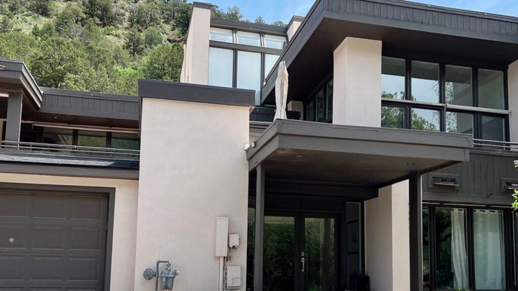 black fox on an exterior with taupe stucco, black windows, midwest landscape and modern contemporary style