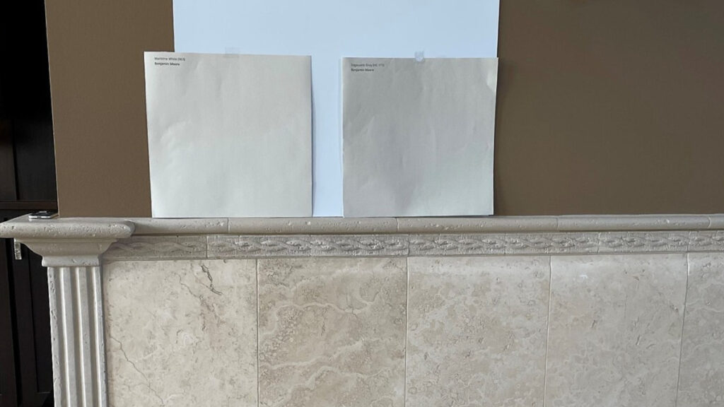 Benjamin Moore Maritime White with limestone or travertine tile accents on walls, Edgecomb Gray is the other sample