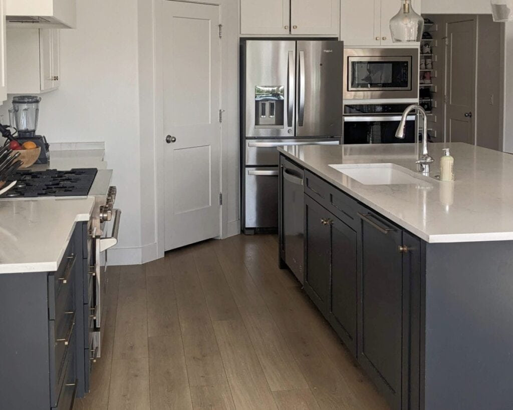 Farrow and Ball Railings, soft black paint color on lower kitchen cabinets, Snowbound and Pure White, soft white quartz countertop, wood flooring