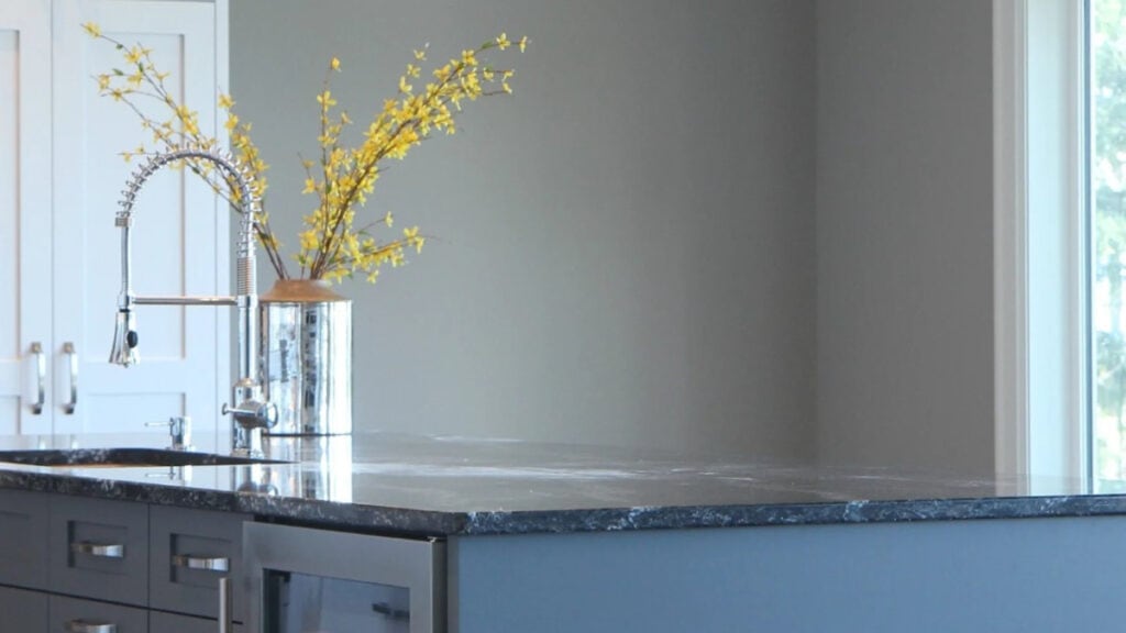 Sherwin Williams Dovetail in kitchen with black pendant lights over the dark gray island