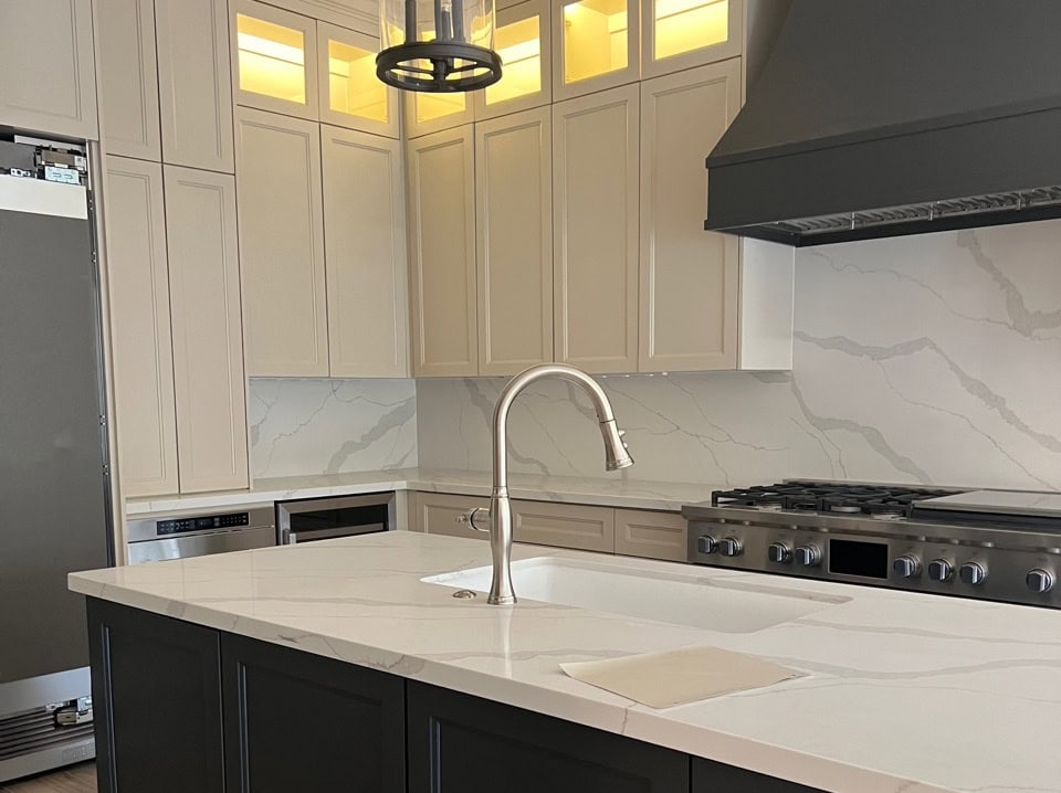 Sherwin Williams Sandbar, white quartz countertop, slab backsplash, Iron Ore range hood and island
