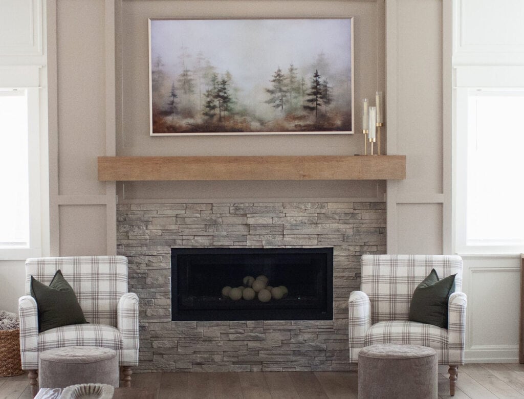 paint color trends for 2026, stacked stone beige and gray fireplace, Sherwin Williams Balanced Beige and White Snow with wood mantel and accent chairs